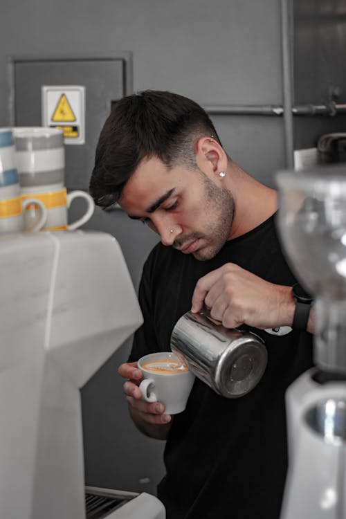 Barista Standing behind the Counter Making Latte Art 