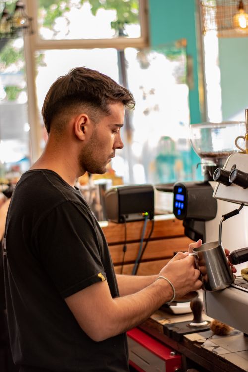 Free Barista focusing on making coffee with espresso machine at café, held by NIKON D5500. Stock Photo