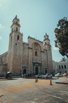 A grand Catholic cathedral in Mérida, Mexico, under a clear blue sky, showcasing colonial architecture.