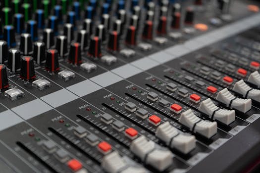 Close-up of a professional audio mixer showcasing control dials and sliders used in sound mixing.
