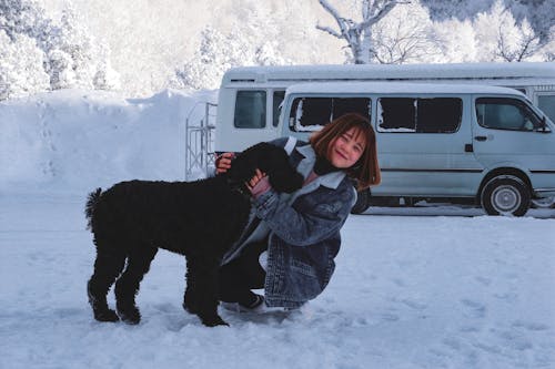 Femme étreignant Un Chien Noir à Poil Court