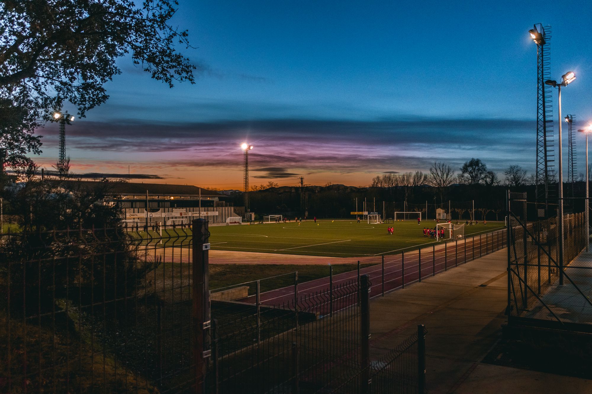 Estadio de futbol con césped iluminado por reflectores durante un partido nocturno