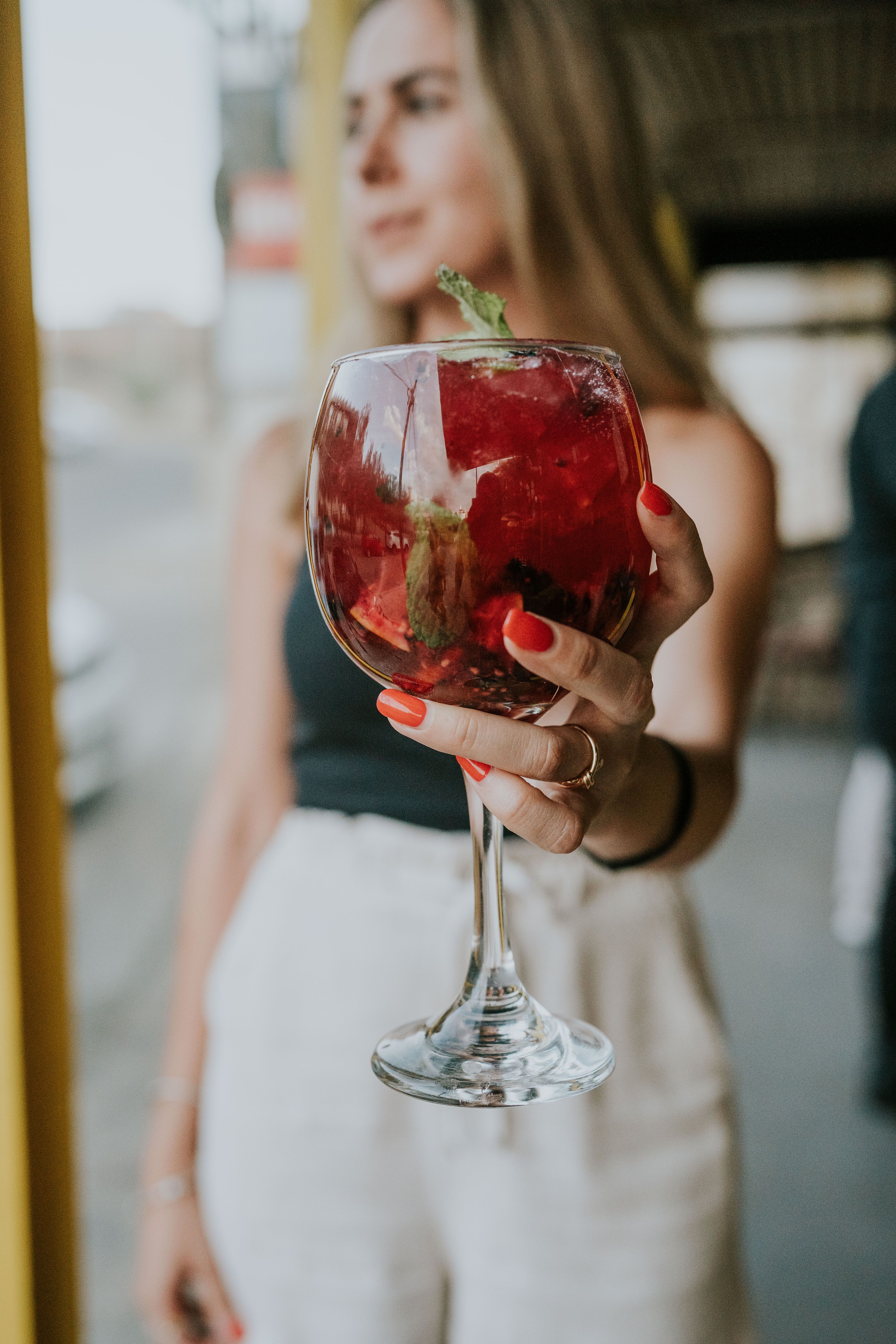 Woman holding a glass of red wine · Free Stock Photo
