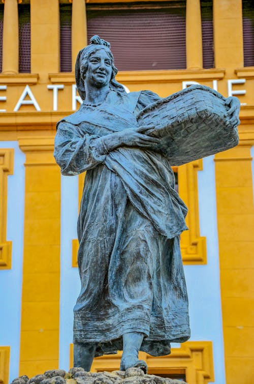 A Sculpture of a Woman Carrying a Basket 