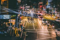 夜间，骑自行车穿行于交通繁忙的城市景观中，展现出繁华的夜生活氛围