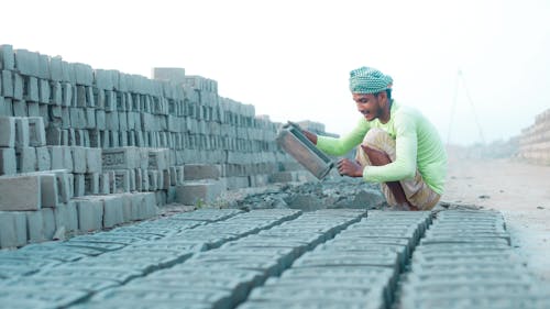 Man Laying Bricks on a Construction Site 