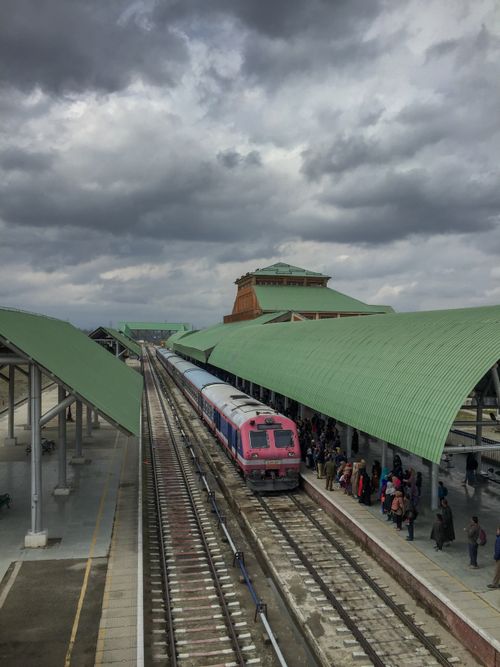 Free A vibrant train awaits passengers at the scenic Srinagar Railway Station under a cloudy sky. Stock Photo