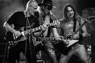 黑白图像中，摇滚乐队在舞台上热情地用吉他表演