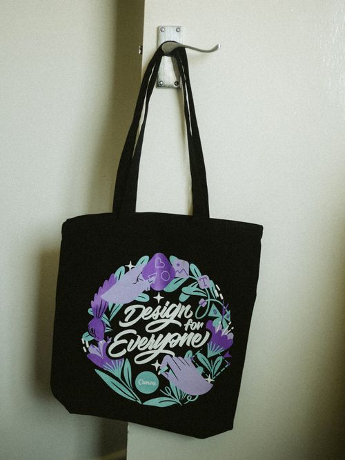 Free A stylish black tote bag with a floral design hanging on a door hook indoors. Stock Photo