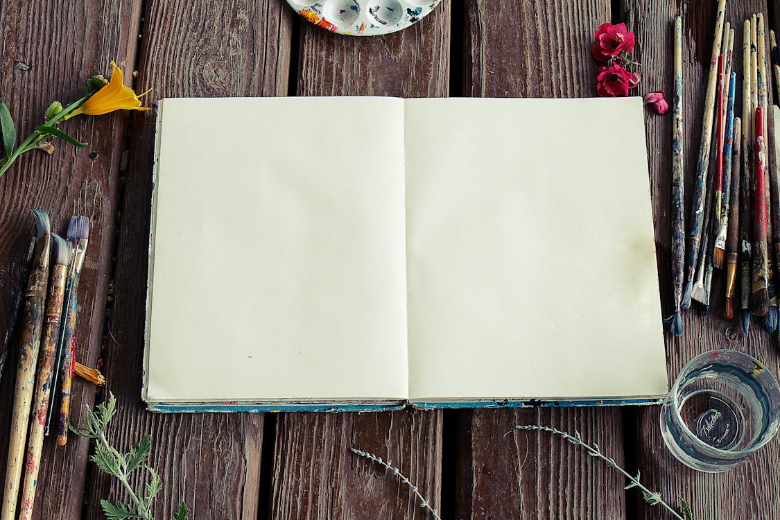 Free Photograph of Blank Sketchbook and Paint Brushes Stock Photo