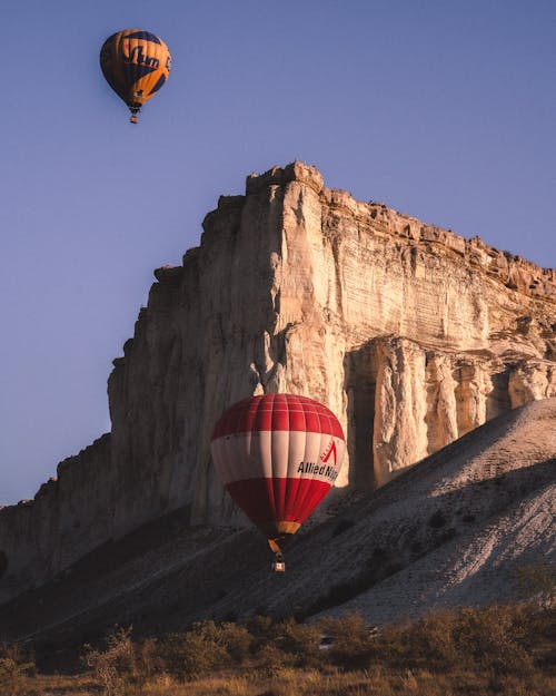 Balloons Flying near Rock Formation