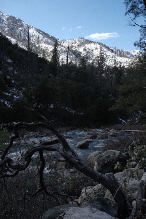 Free A tranquil winter scene in Yosemite Valley with snow-capped mountains and flowing river. Stock Photo