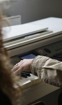 A close-up photo of a person's hands playing a digital piano, with a focus on touch and expression.