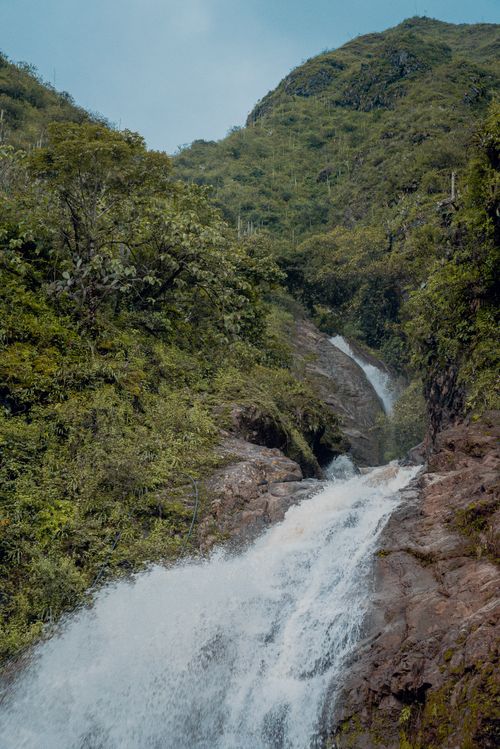 Free Breathtaking view of a waterfall cascading through the lush green forest in San Pablo, Cajamarca, Peru. Stock Photo