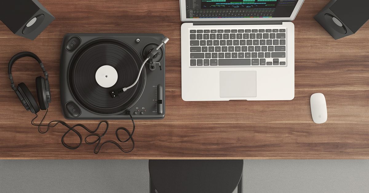 Top view of a music production desk with a laptop and turntable setup for modern audio production.