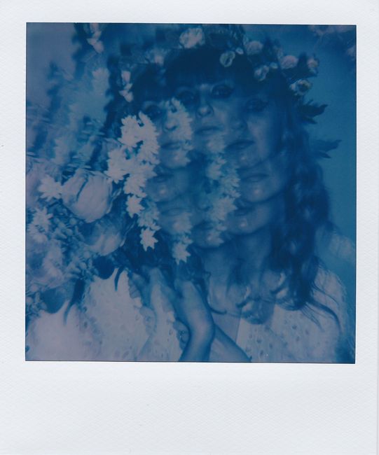 Artistic double exposure of a woman with flowers, creating a surreal and dreamy effect.