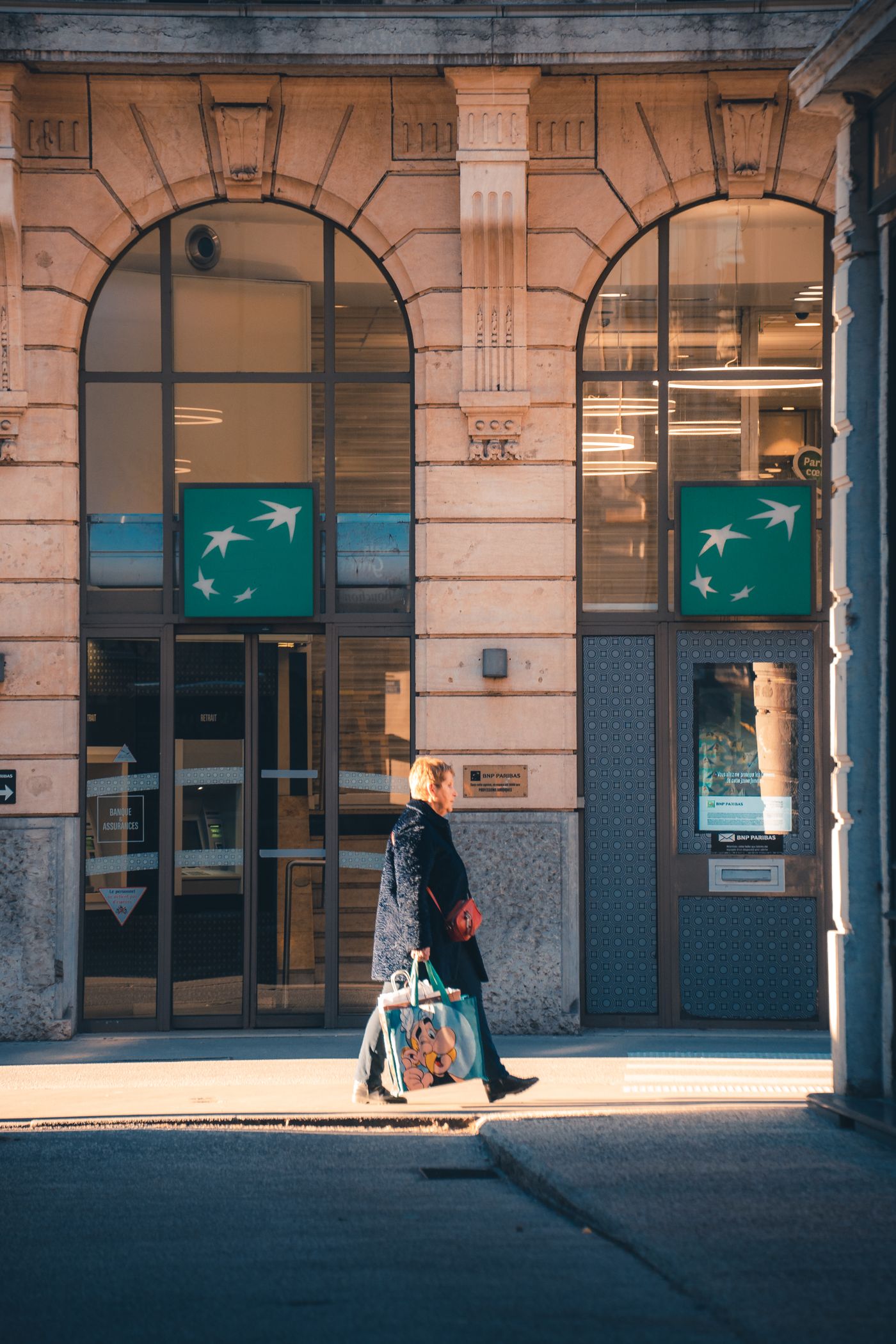 Piéton passant devant la façade d'une banque à Lyon