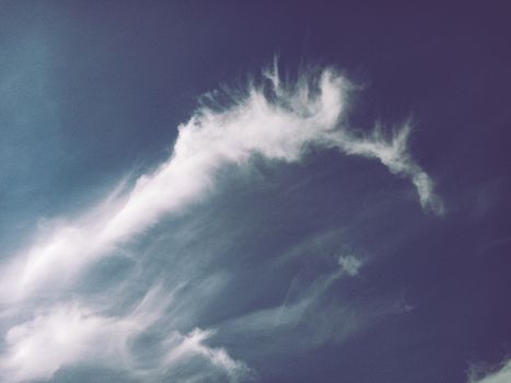 Delicate white clouds stretch across a clear blue sky, creating a serene and calming scene.
