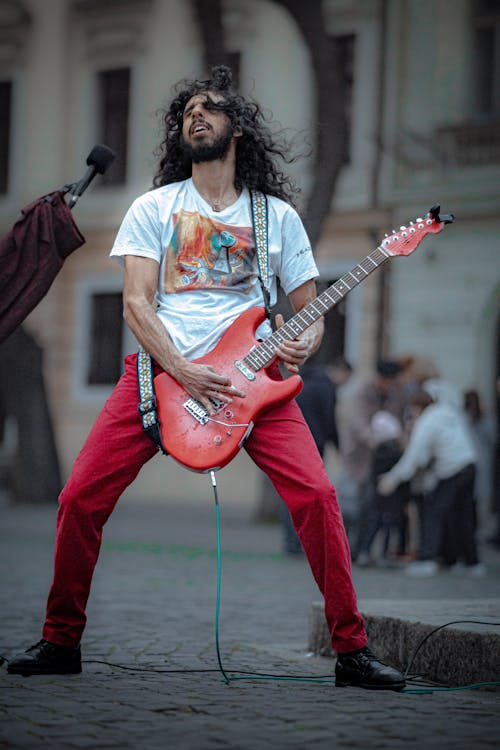 Man Playing an Electric Guitar in City