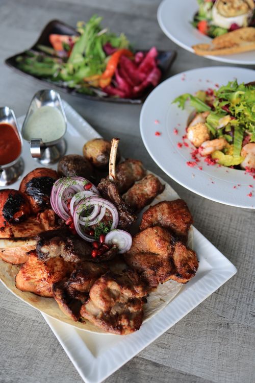 Free Delicious grilled meat platter with fresh salads, perfect for a savory meal. Stock Photo