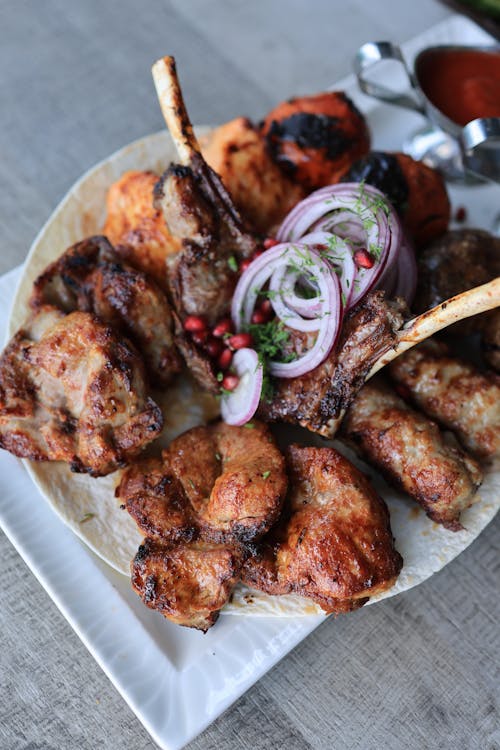 Free A Plate of Meat Barbecue with Onions and Pomegranate Seeds Stock Photo