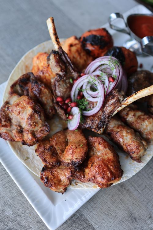 Free A mouthwatering assortment of grilled meats, served with onions and sauces. Perfect for dinner. Stock Photo