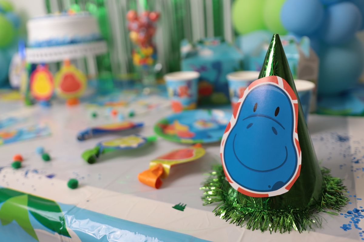 Vibrant dinosaur-themed birthday party decorations on a table setup for kids Stock Photo.