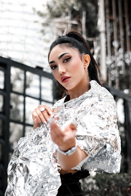 Woman Wearing Tinfoil Dress Reaching her Hand out