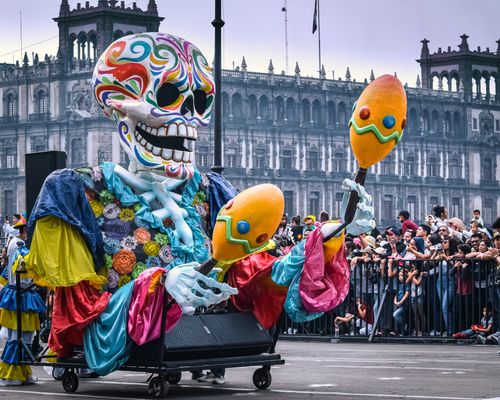 Free Vibrant Day of the Dead parade with a festive skeleton float in Mexico City. Stock Photo