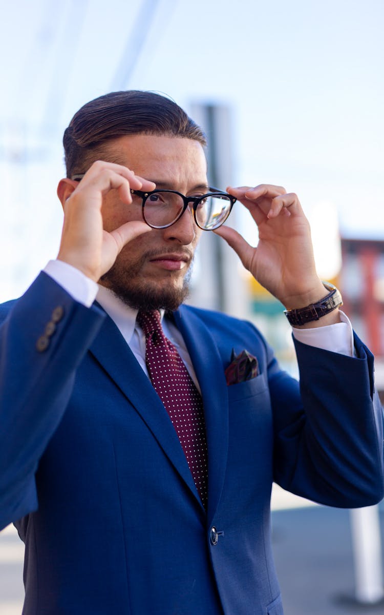 Man In Suit Adjusting Eyeglasses