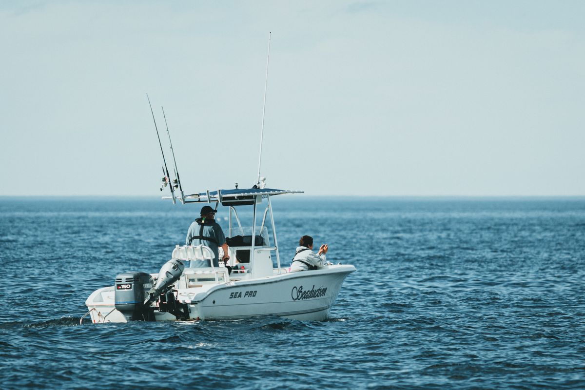 Two anglers aboard a charter boat trolling in deep blue water