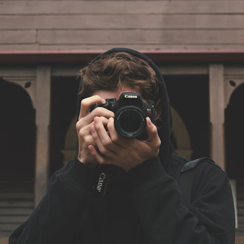 Person Holding Camera and Taking Pictures