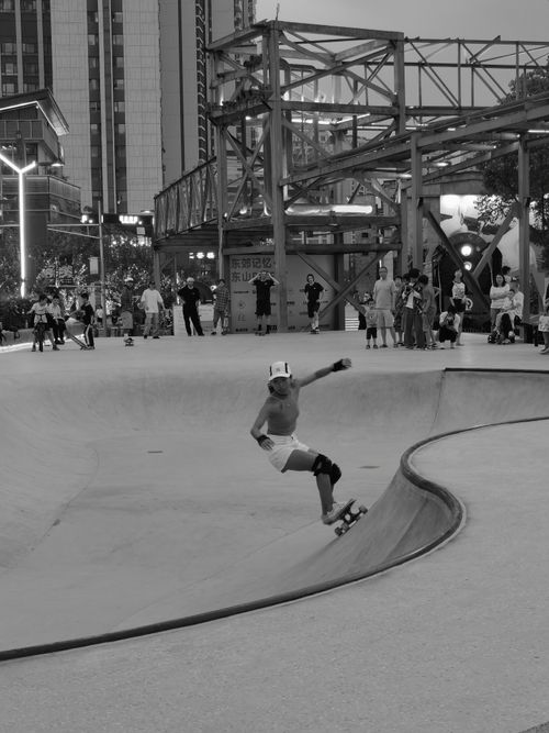 Free Black and white photo of an urban skatepark scene with skateboarders enjoying the ramps. Stock Photo