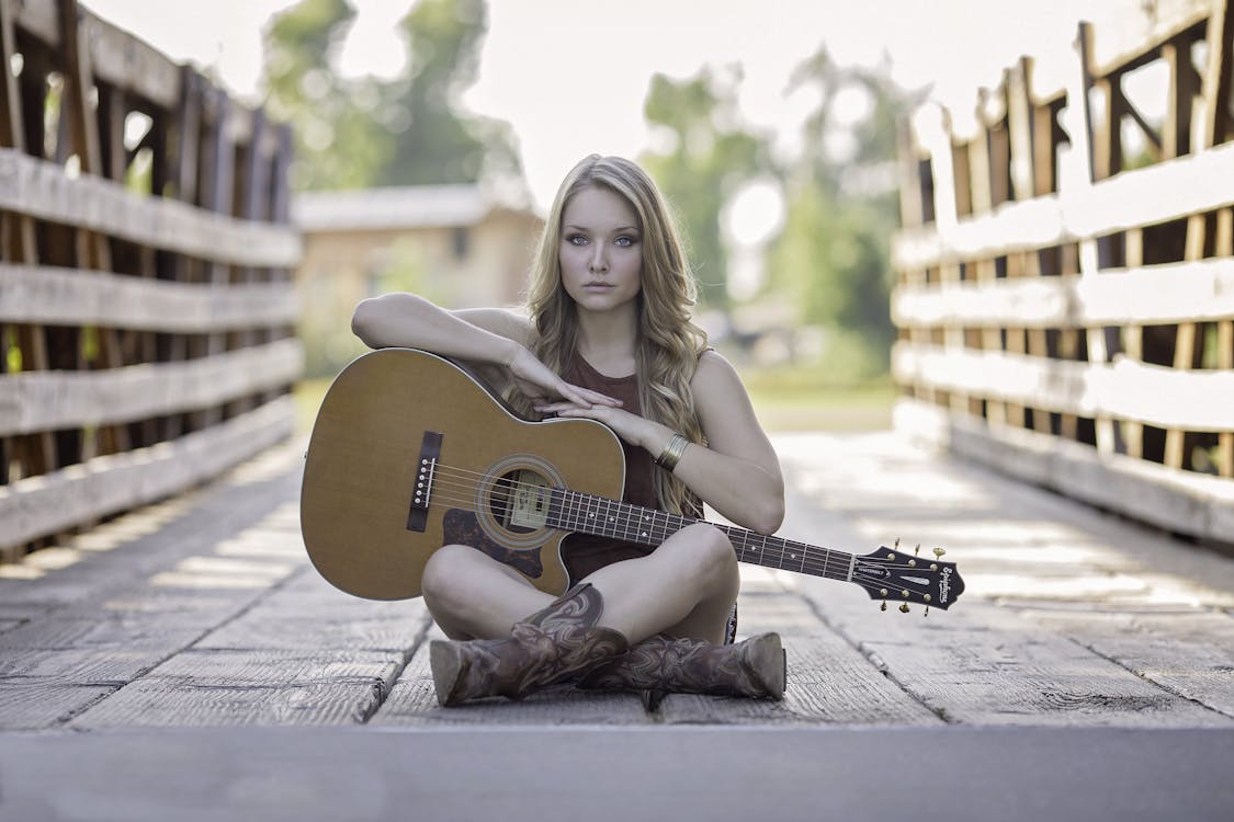 무료 낮 동안 클래식 기타를 들고 앉아있는 여자 스톡 사진