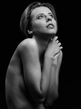 Black and white studio portrait of a young woman posing with grace.