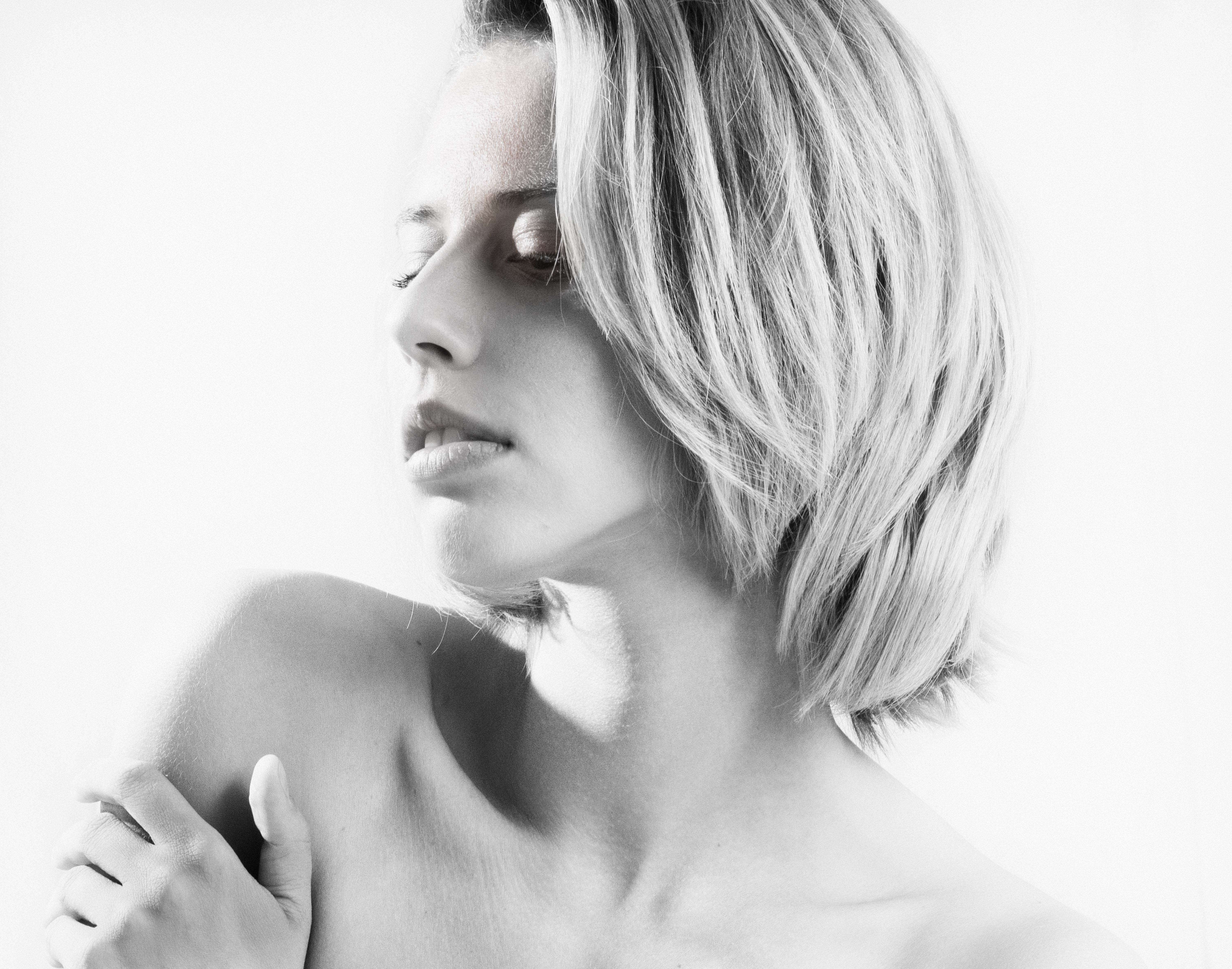 Graceful black and white portrait of a young woman with closed eyes, exuding calmness.