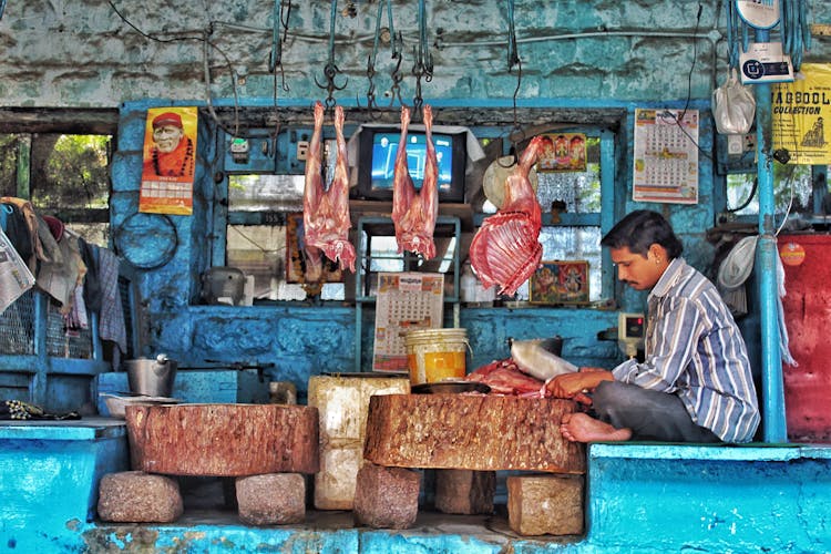 Butcher Sitting In Store