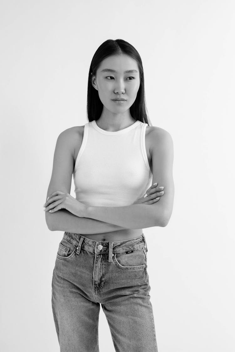 Black And White Photo Of Woman Standing With Arms Crossed