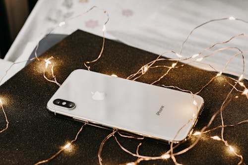 Free Close-Up Photo of iPhone Near String Lights Stock Photo