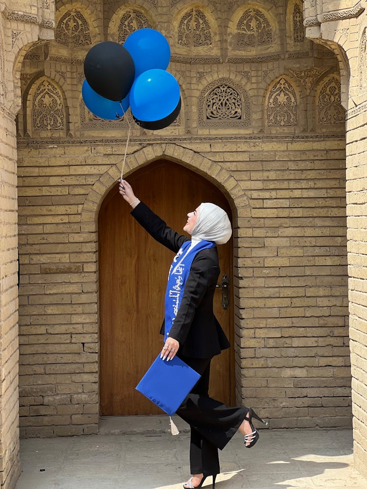 Smiling Graduate Woman Holding Balloons