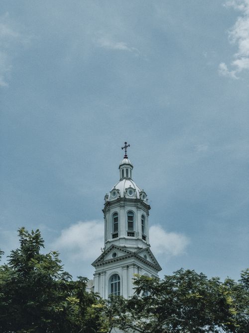 Free Elevated view of the Sacred Heart Church tower against a cloudy sky in Singapore. Iconic religious landmark. Stock Photo