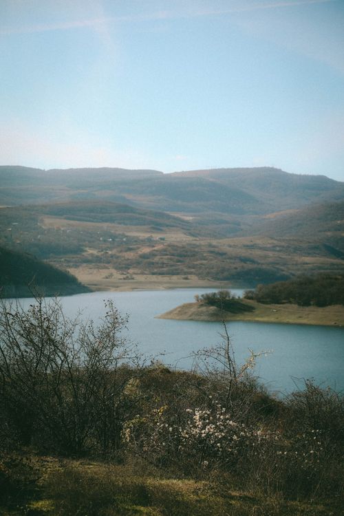 Free A breathtaking view of Tbilisi's rolling hills and tranquil lake, enveloped by lush nature. Stock Photo
