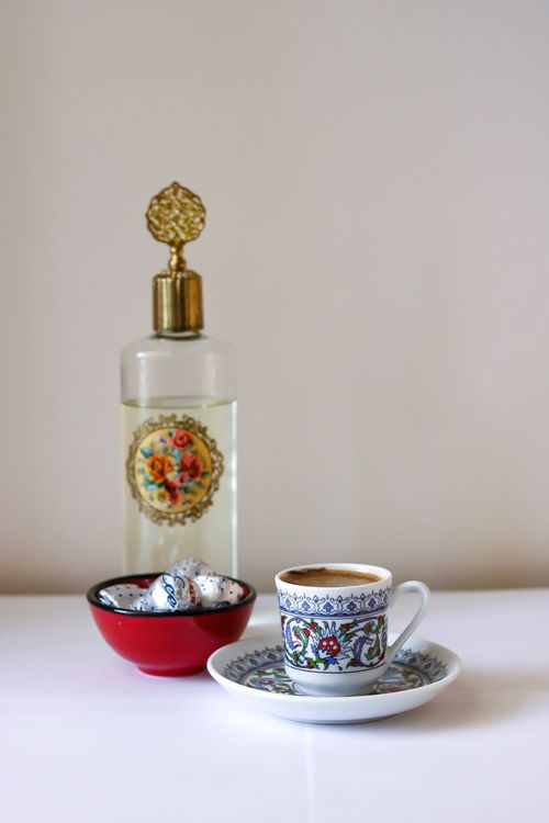 Free Elegant coffee setup featuring Turkish-style cup, saucer, bottle, and sweets. Stock Photo