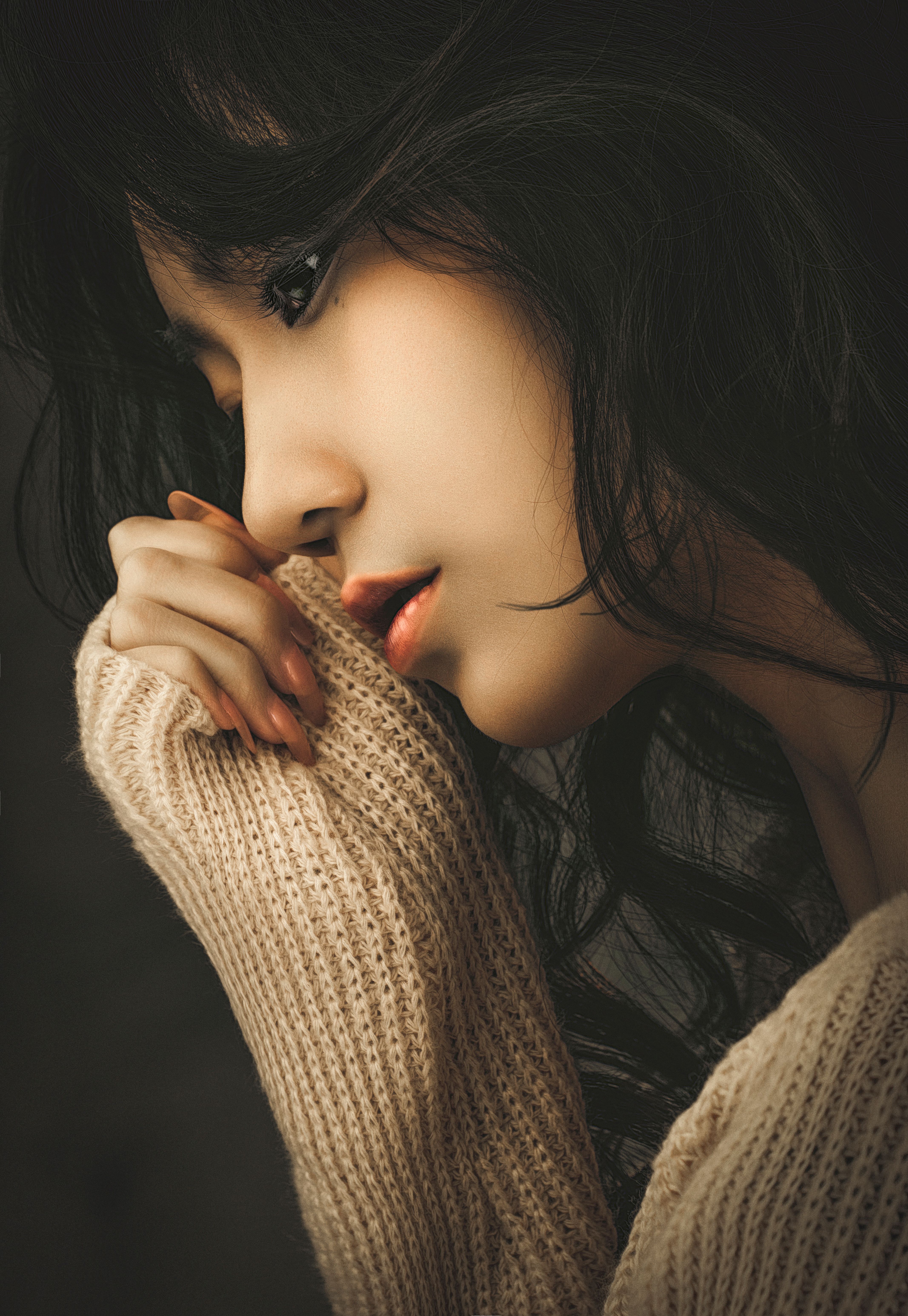 Close-up profile of a young woman in a cozy sweater, exuding serenity and warmth.
