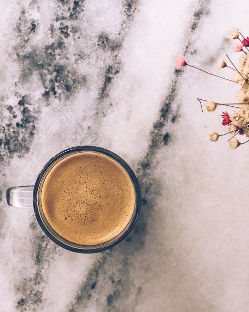 Cup of Coffee on Marble Table and Flower Decoration