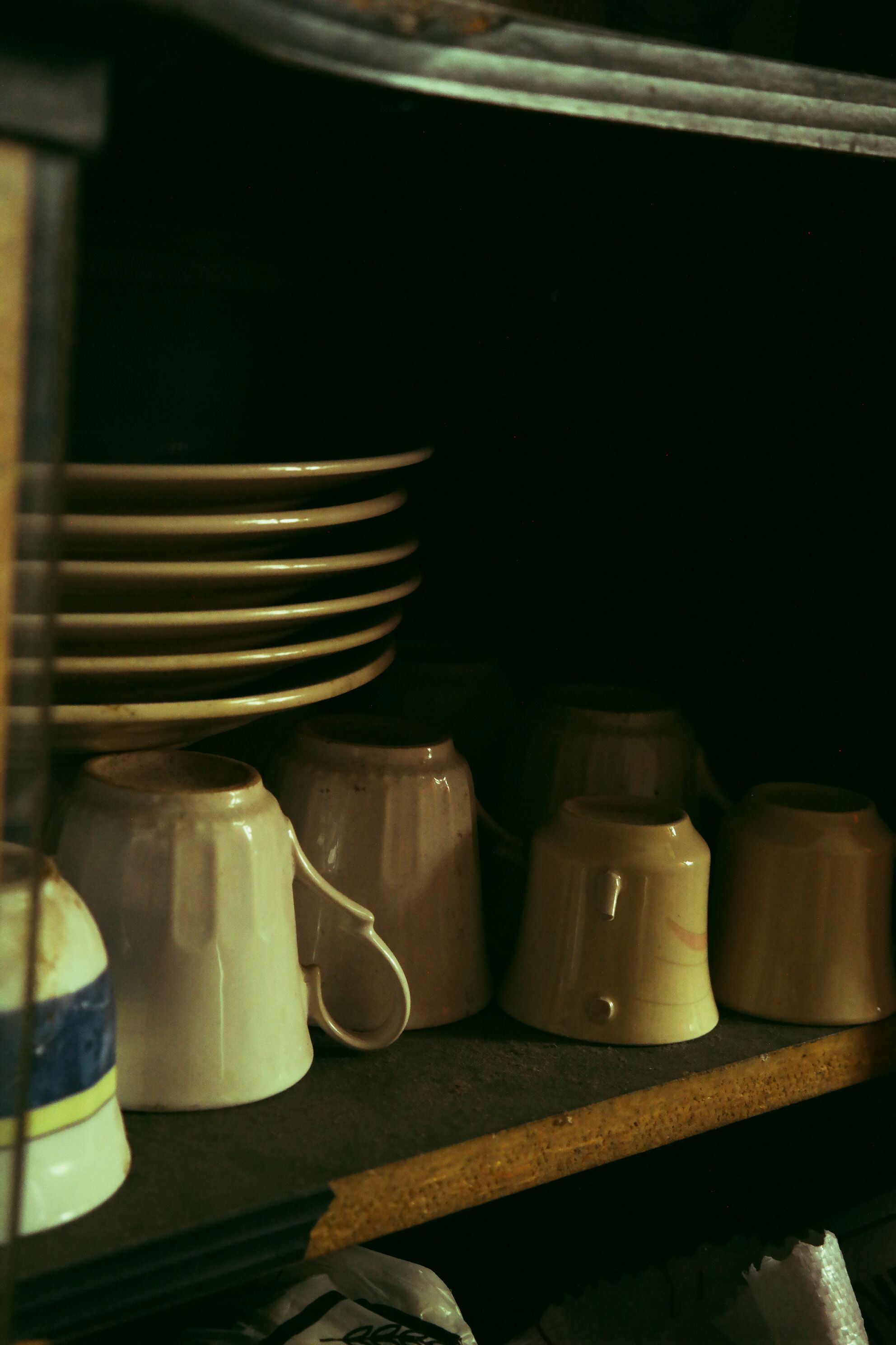 Weathered wood vintage mug rack mounted above a cozy coffee bar hutch display
