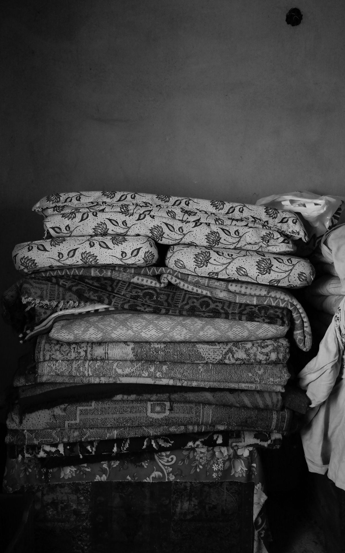 Folded blankets, sheets, pillows, and bedding stacked together