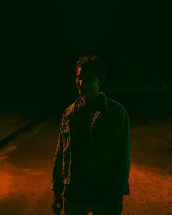 Lone figure lit by warm rim light on a dark road — photo by Alejandro Castillo Lopez on Pexels