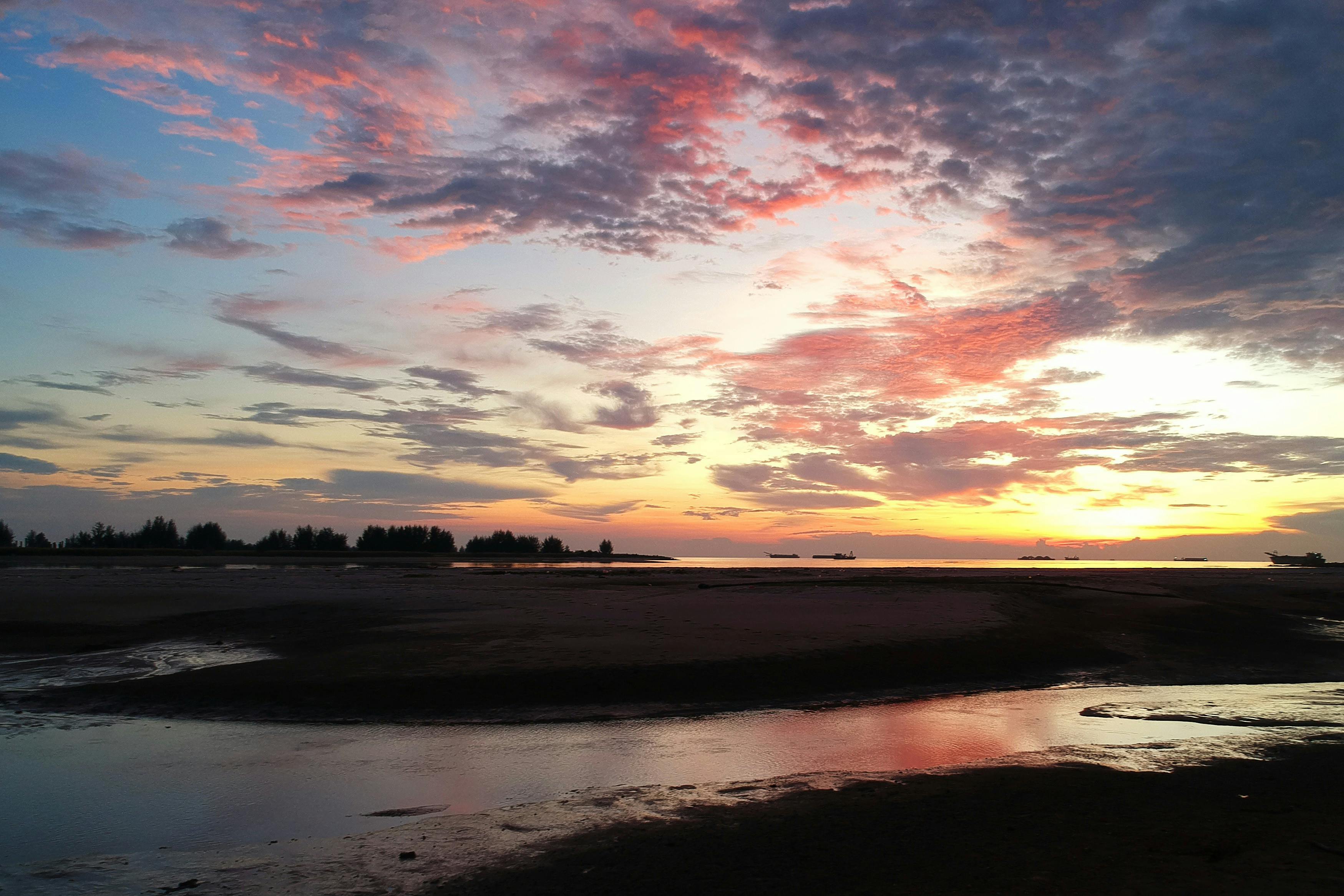 马拉卡海滩上，云雾缭绕，日落色彩鲜艳，令人惊叹