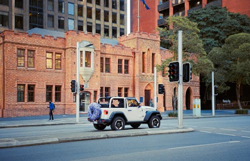 A jeep driving down a street in front of a building